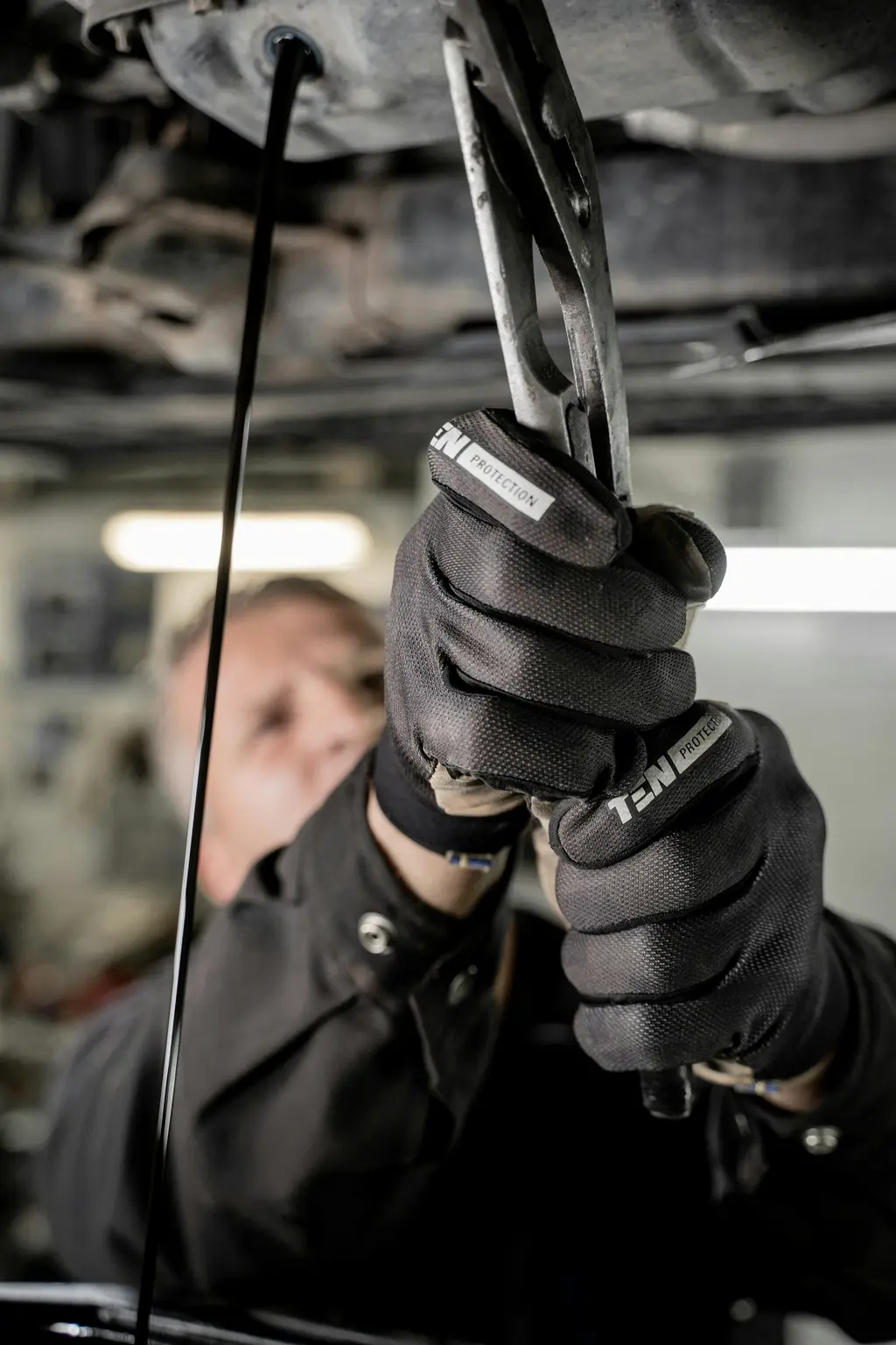 Mecánico con guantes trabajando en un auto